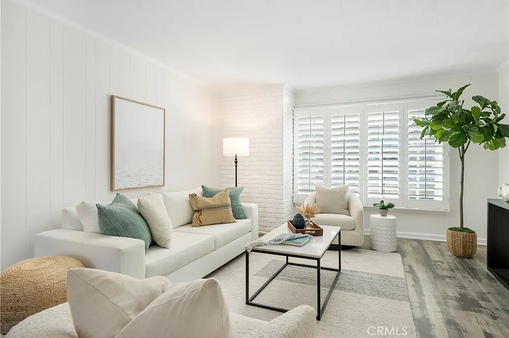 living room with white walls and floors, featuring a white couch and armchair