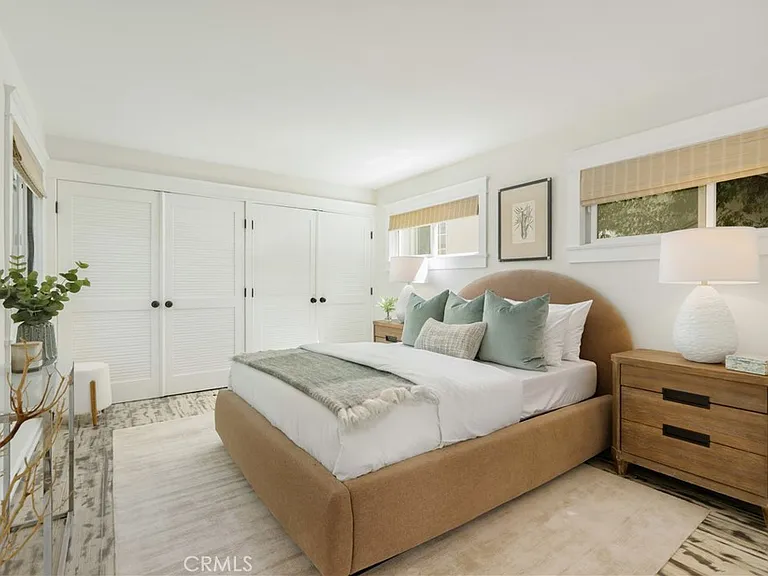 bedroom with a brown bed, white bedding, and green pillows.